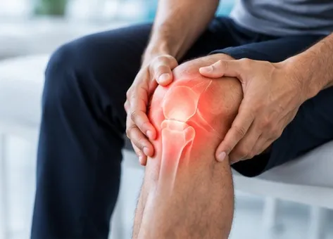 Seated person holding a painful knee